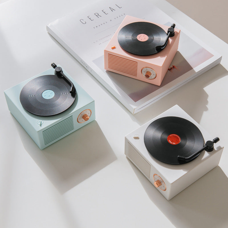 Wireless Bluetooth speaker designs in pastel colors on a white table next to a magazine.